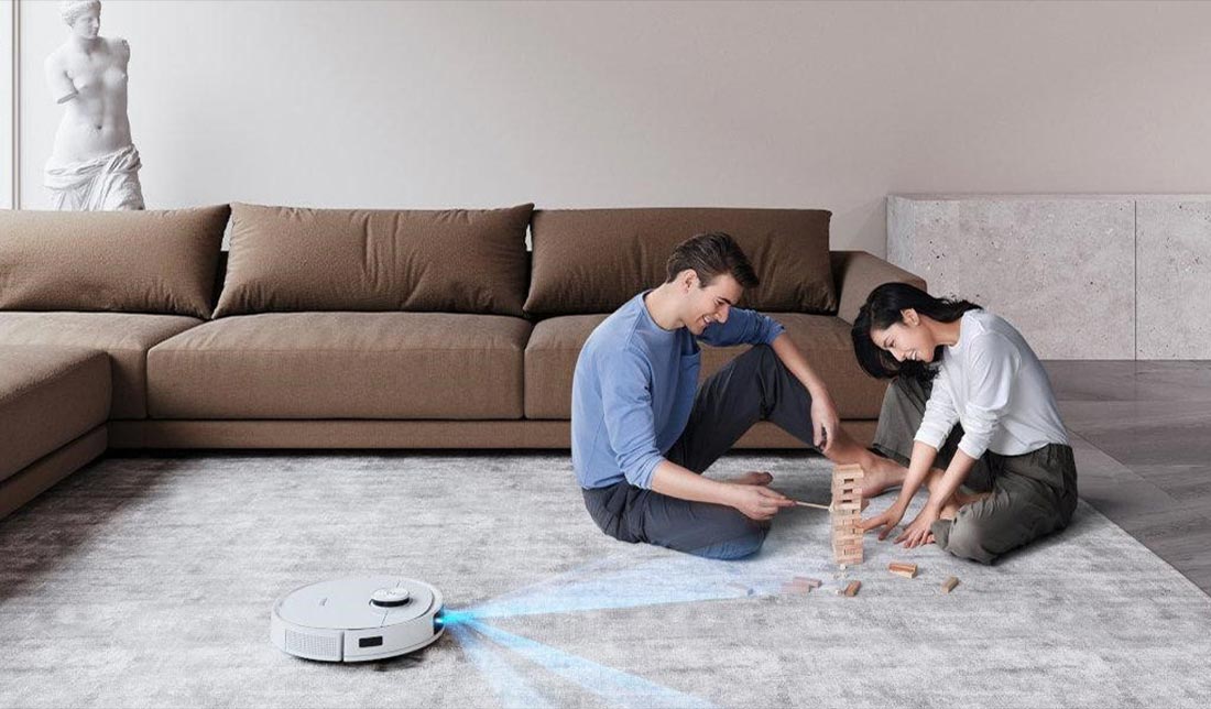 نمایش یک خانواده در حال بازی کردن درحالی که جاروبرقی رباتیک در حال نظافت منزل است